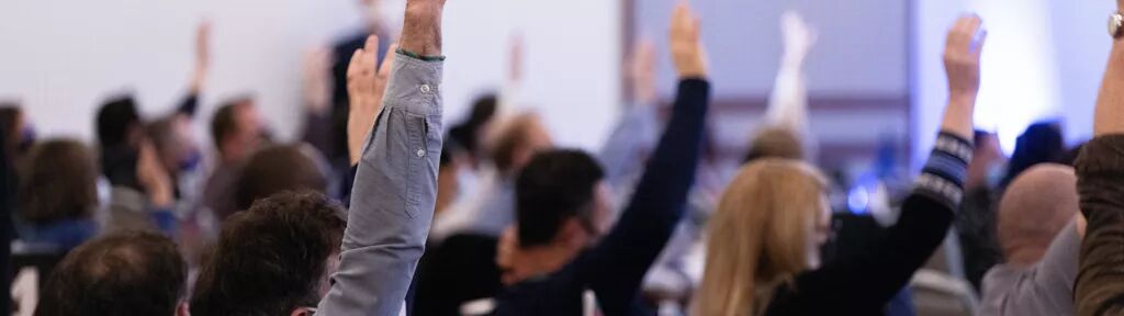 People raising their hands to vote
