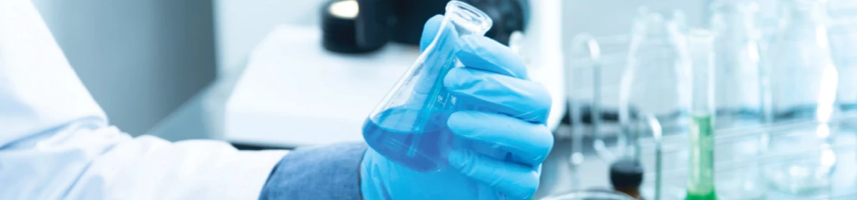 Hands in a blue gloves holding test tubes