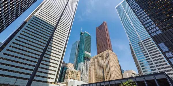 A low-angle photo of financial towers in downtown Toronto against a blue sky