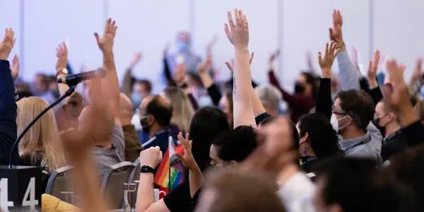 A group of AMAPCEO Delegates raising their hand to vote 