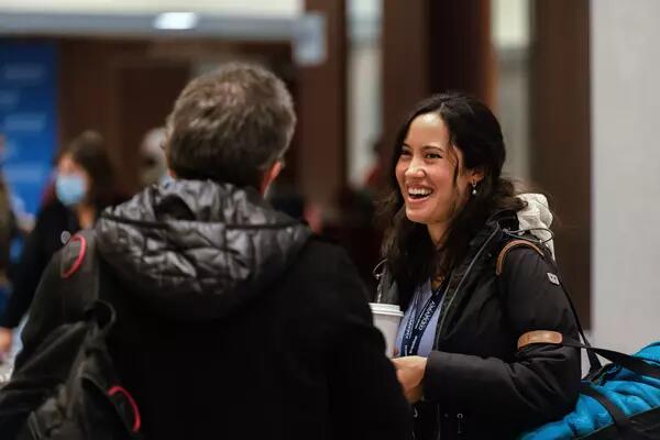 Two members smiling and talking at an AMAPCEO event