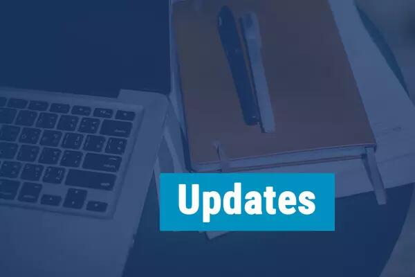 "Updates" with a picture of a laptop, agenda and some pens