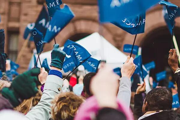 Crowd of people waving AMAPCEO flag