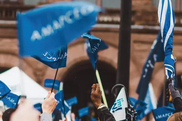 A large group of members outside of Queen's Park, holding AMAPCEO flags.