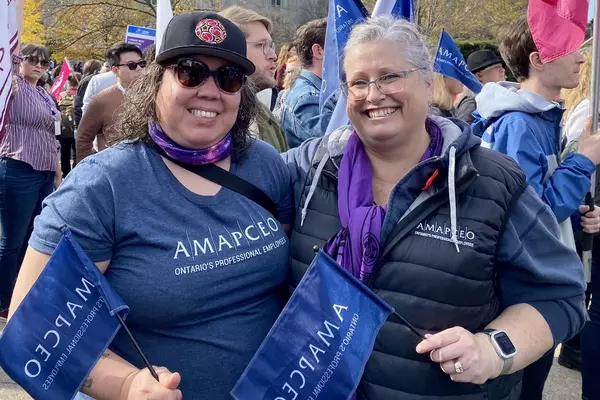Cynthia Watt and Waasmowin-Mnidoo waving AMAPCEO flags