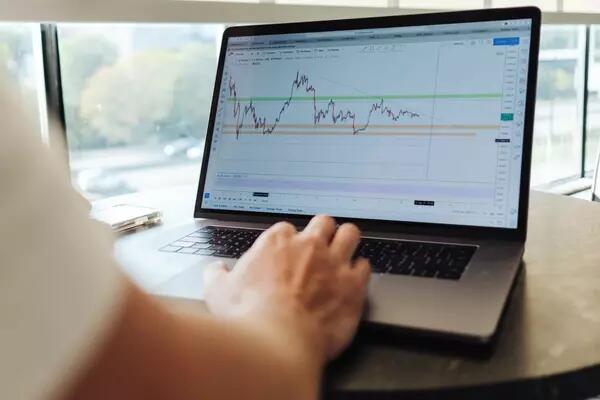 A person using a laptop computer that is displaying financial analytics