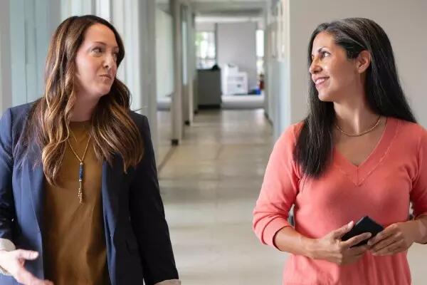 Two people talking in a hallway