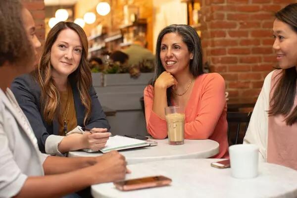 Group of people gathered in a cafe talking 