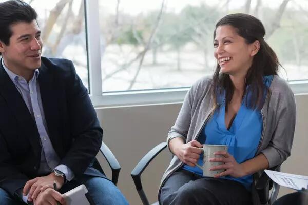 Two people sitting side by side smiling