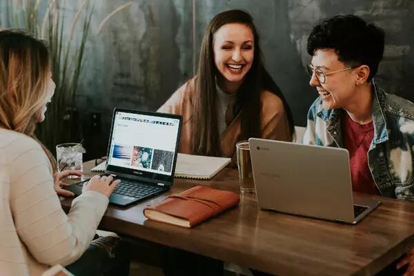 Group of smiling people looking at laptops