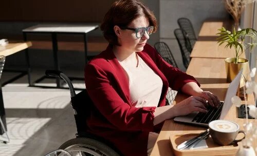 person in wheel chair working on laptop