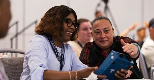 Two AMAPCEO members looking at an air quality monitor