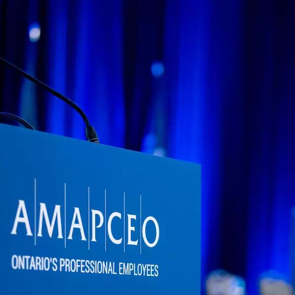 A mic on a podium with the AMAPCEO logo