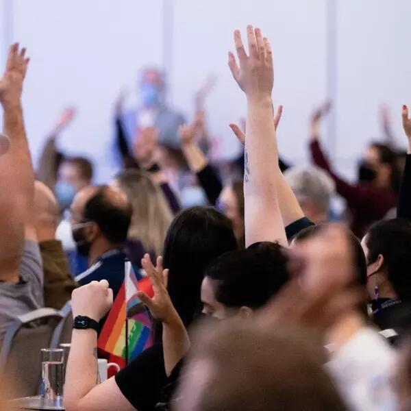 A group of AMAPCEO Delegates raising their hand to vote 