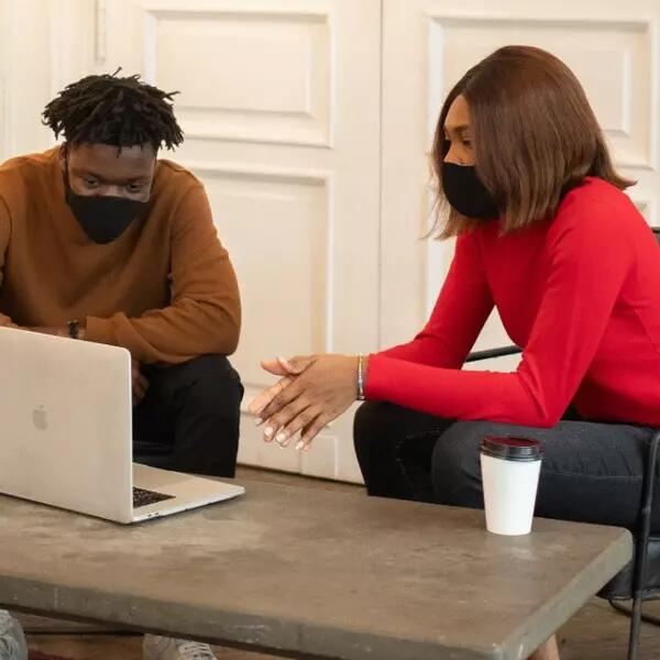 Two AMAPCEO members wearing masks looking at a laptop