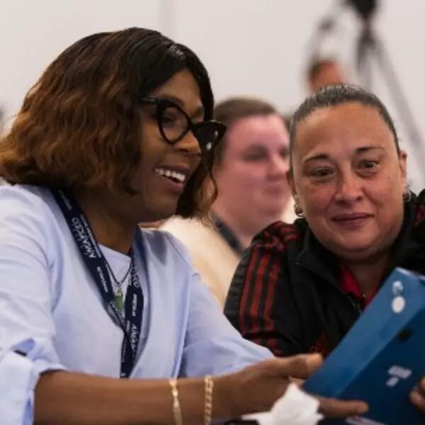 Two AMAPCEO members looking at an air quality monitor