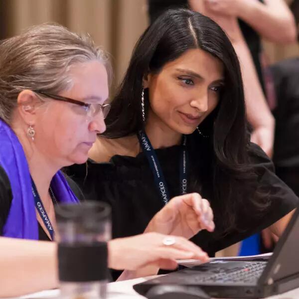 An AMAPCEO Workplace Representative is helping a fellow member. They are both sitting at a laptop.